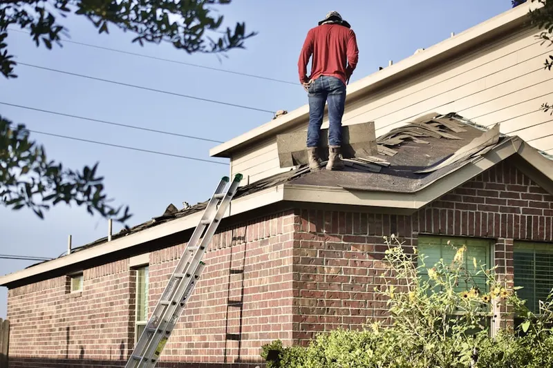Professional roofer working on a residential roof in Camp Dallas